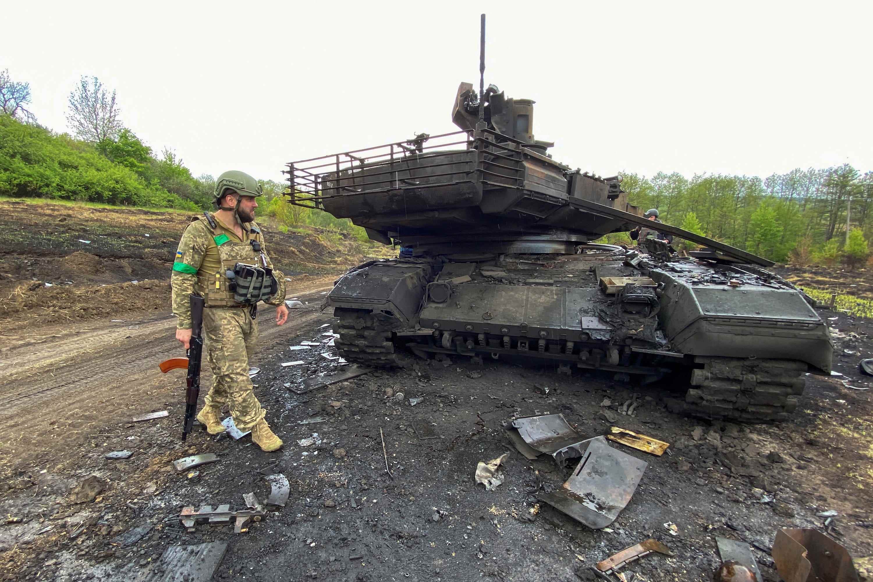 Der ukrainische Soldat geht neben einem zerstörten russischen Kampfpanzer T-90M Proryv, während Russlands Angriff auf die Ukraine weitergeht, in der Nähe des Dorfes Staryi Saltiv in der Region Charkiw, Ukraine, 9. Mai 2022. Bild aufgenommen am 9. Mai 2022. REUTERS/Vitalii Hnidyi