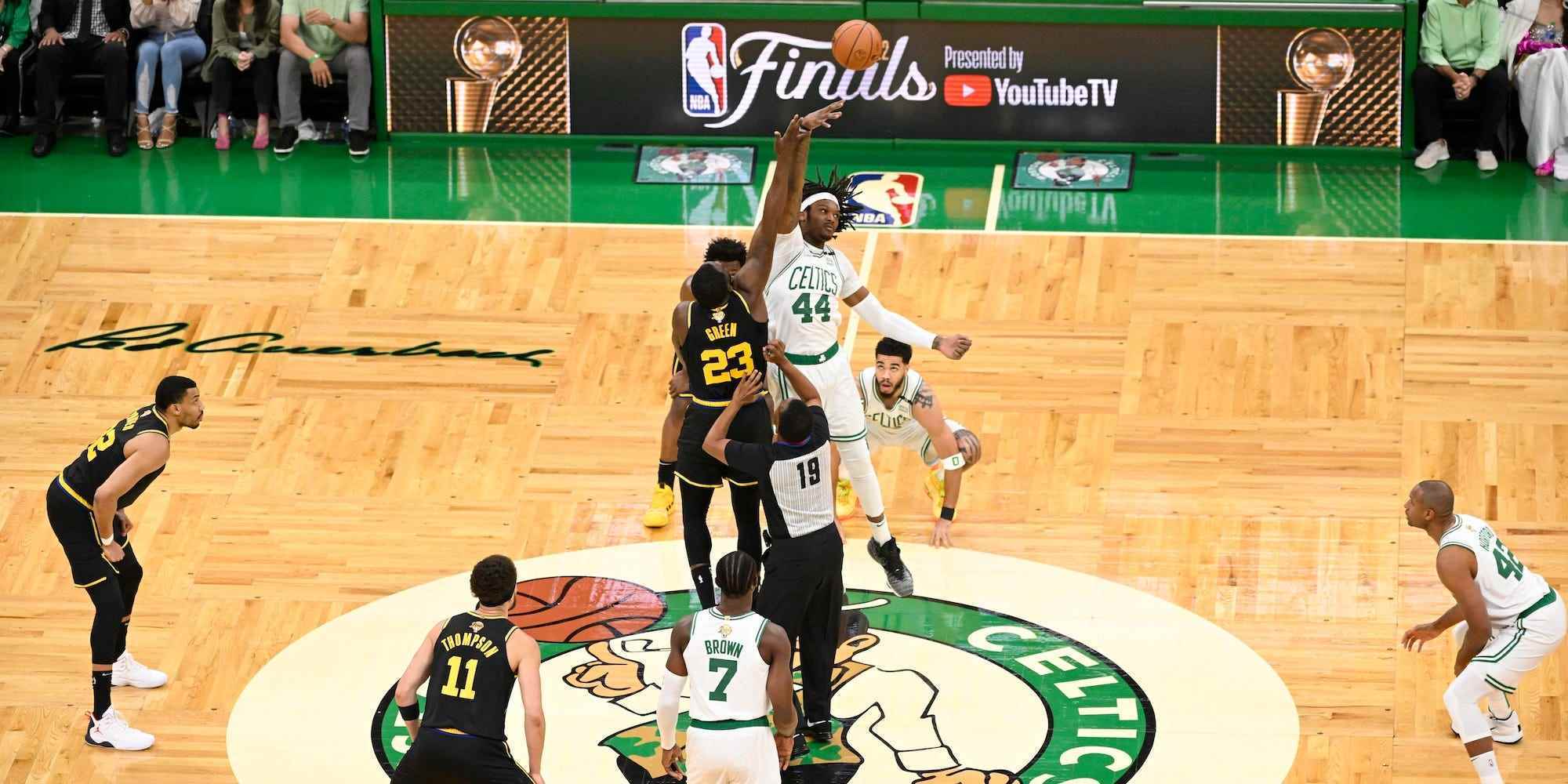 Die Warriors und Celtics springen zu Beginn eines NBA-Finalspiels in der Mitte des Spielfelds um den Ball.