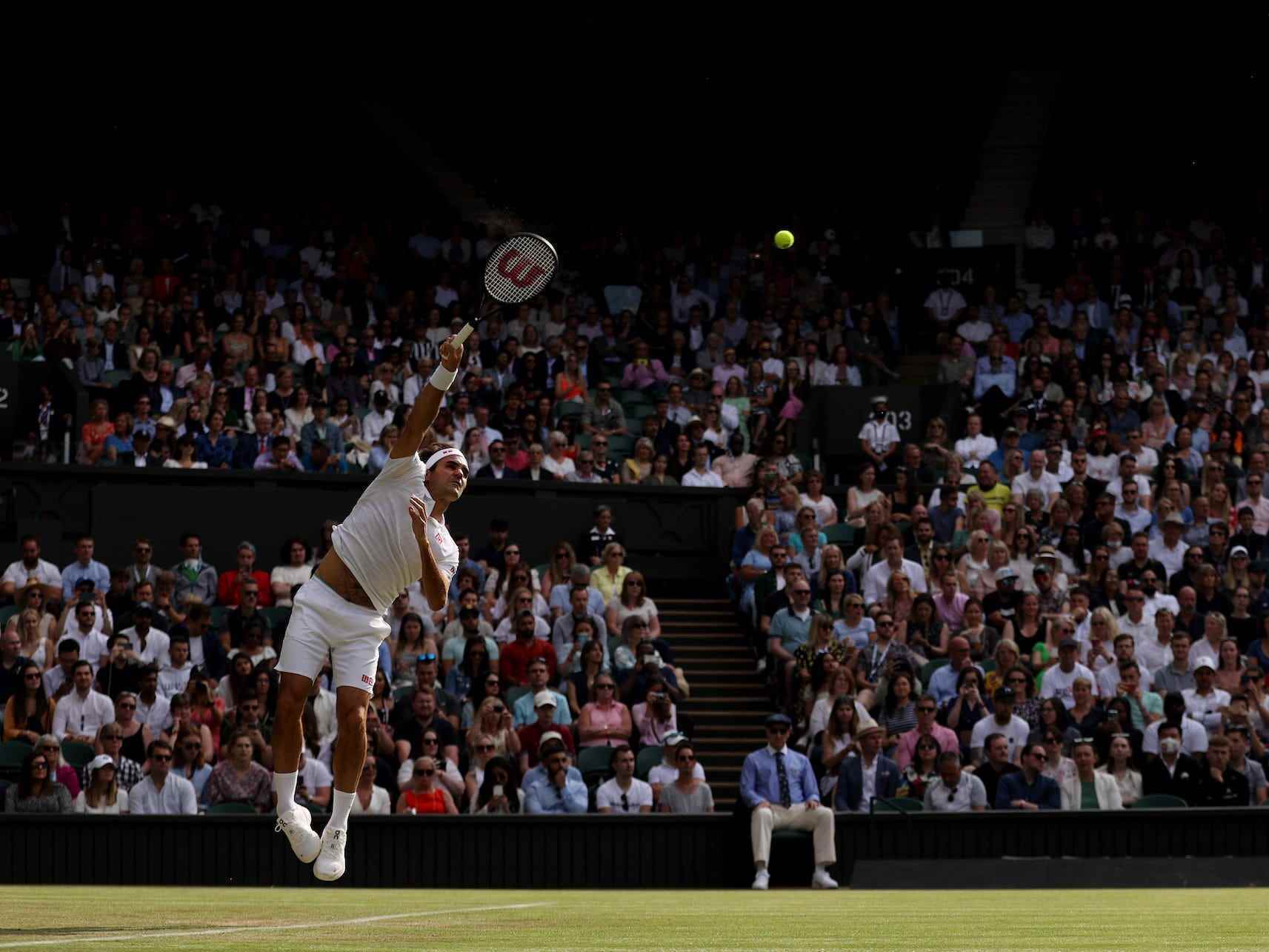 Roger Federer springt in die Luft, während er in Wimbledon dient.
