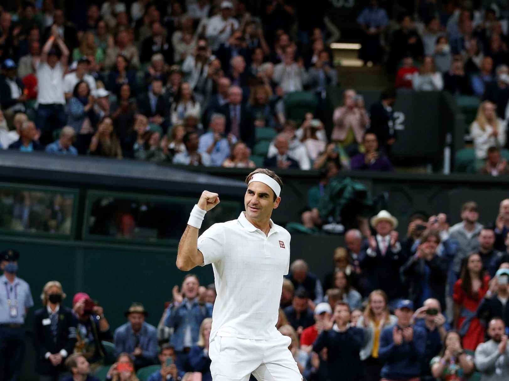 Roger Federer ballt seine Fäuste und lächelt, während die Fans ihn in Wimbledon anfeuern.