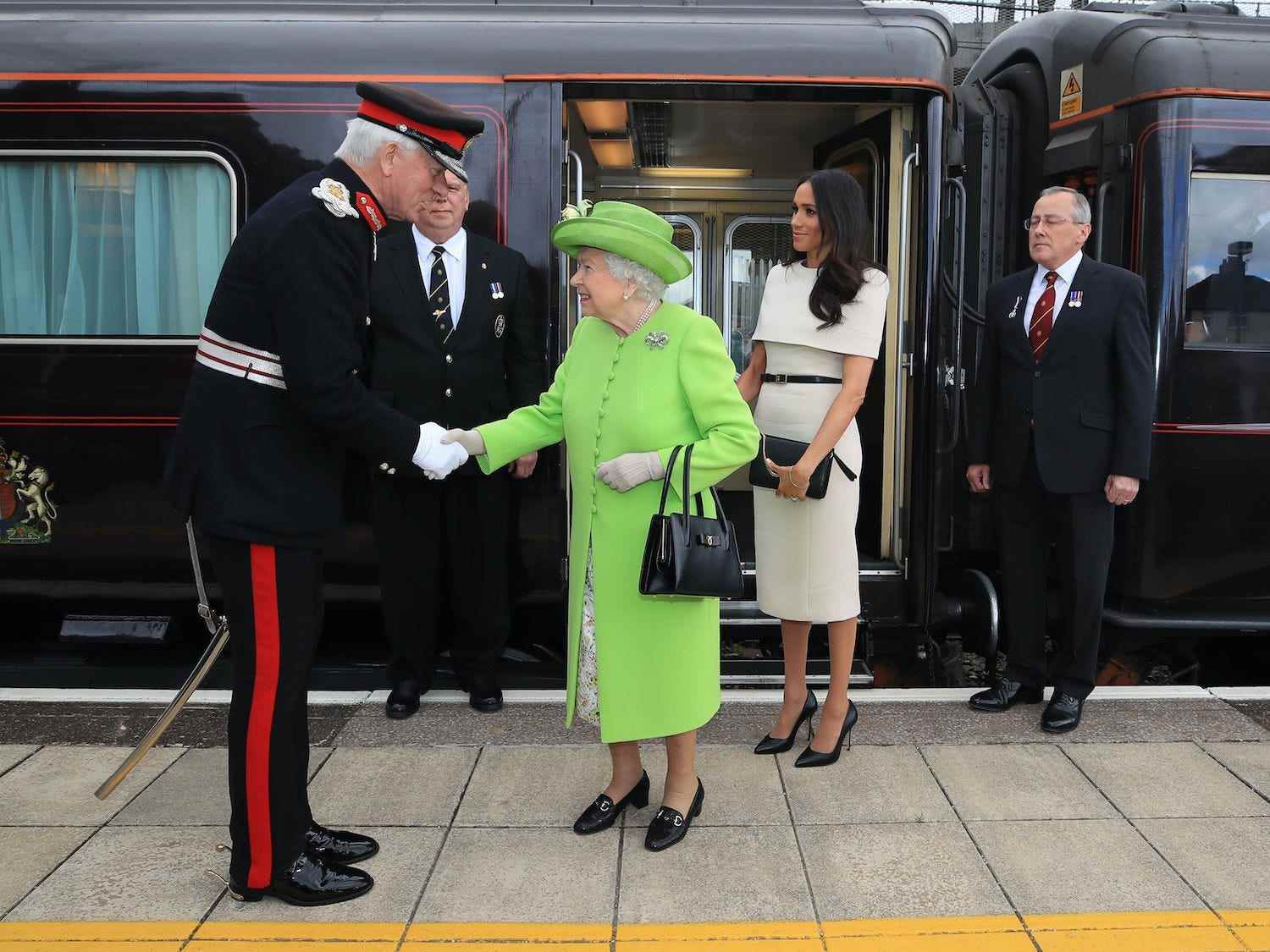 Königin Elizabeth II. wird mit Meghan Markle, Herzogin von Sussex, begrüßt, als sie 2018 mit dem Royal Train am Bahnhof Runcorn in Cheshire, England, ankommen.