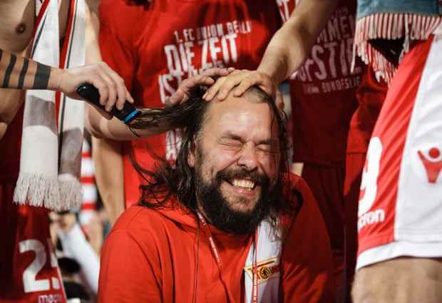 Christian Arbeit, Stadionsprecher und Sprecher von Union Berlin, lässt sich bei der Aufstiegsfeier den Kopf rasieren.