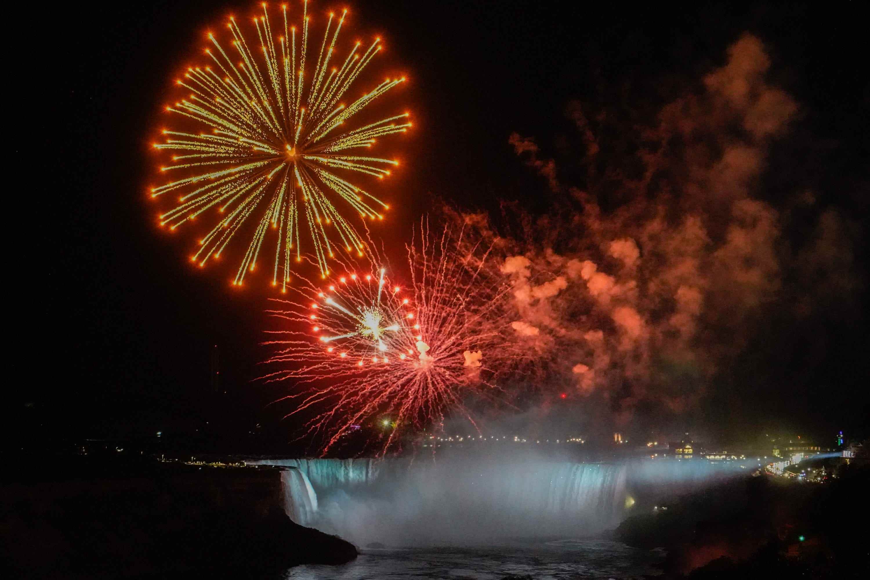 Blick auf die Niagarafälle vom Sheraton Hotelzimmer bei Nacht mit Feuerwerk