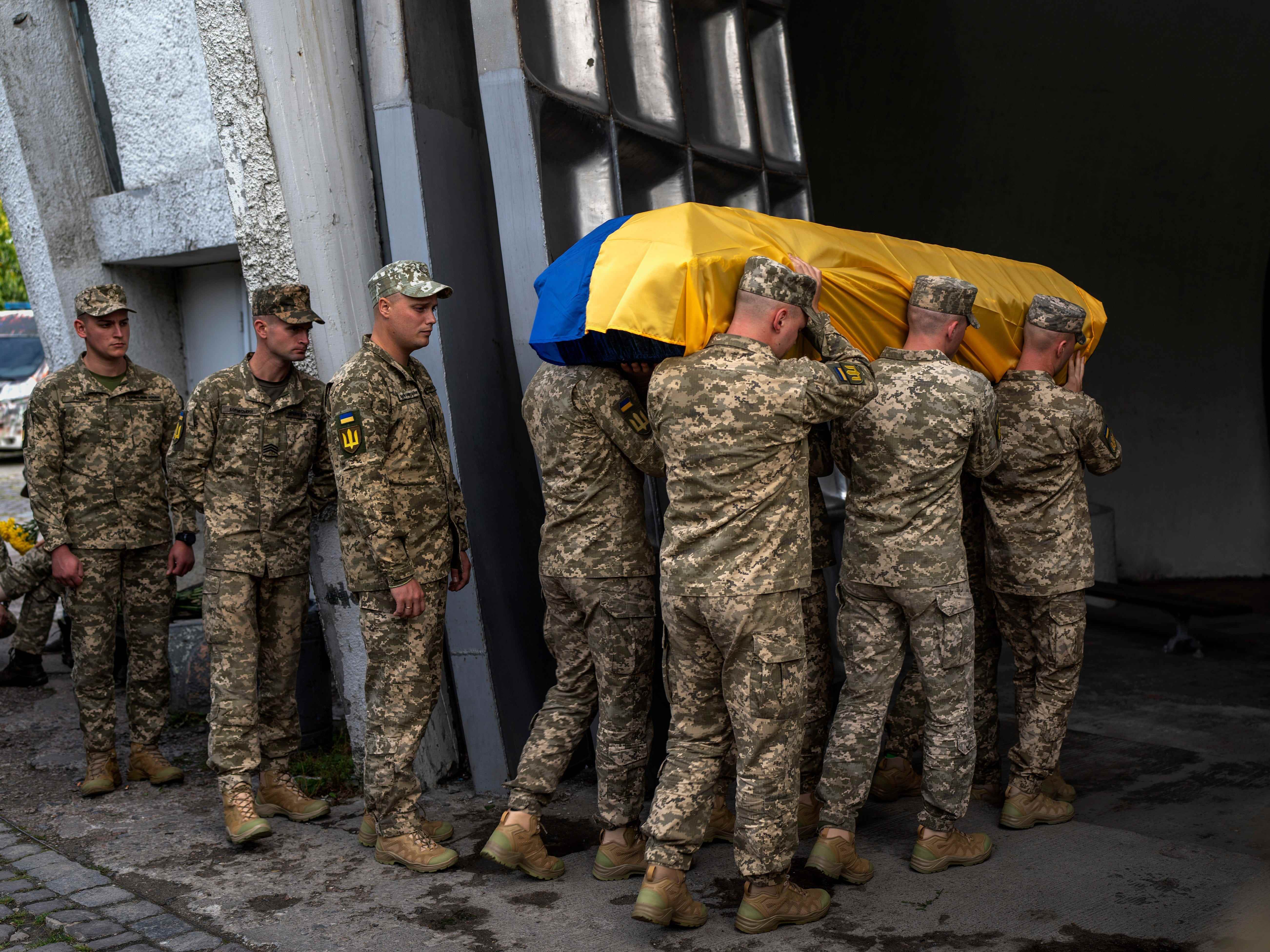 Soldaten tragen den Sarg von Olga Simonova, 34, einer Russin, die in der Region Donezk getötet wurde, als sie auf der Seite der Ukraine im Krieg mit ihrem Heimatland kämpfte, in einem Krematorium in Kiew, Ukraine, Samstag, 17. September 2022.