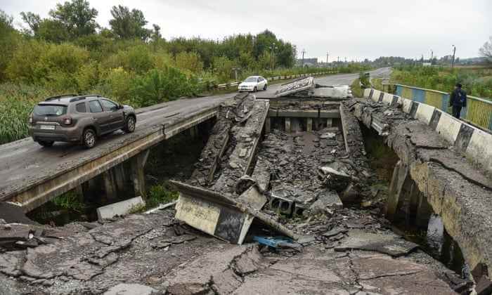 Autos fahren über eine beschädigte Brücke in Charkiw, Ukraine.