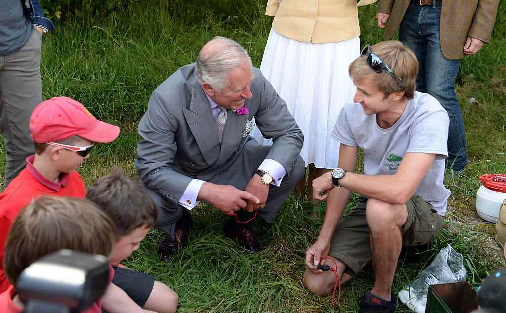 Prinz Charles kniet mit Kindern auf dem Boden nieder