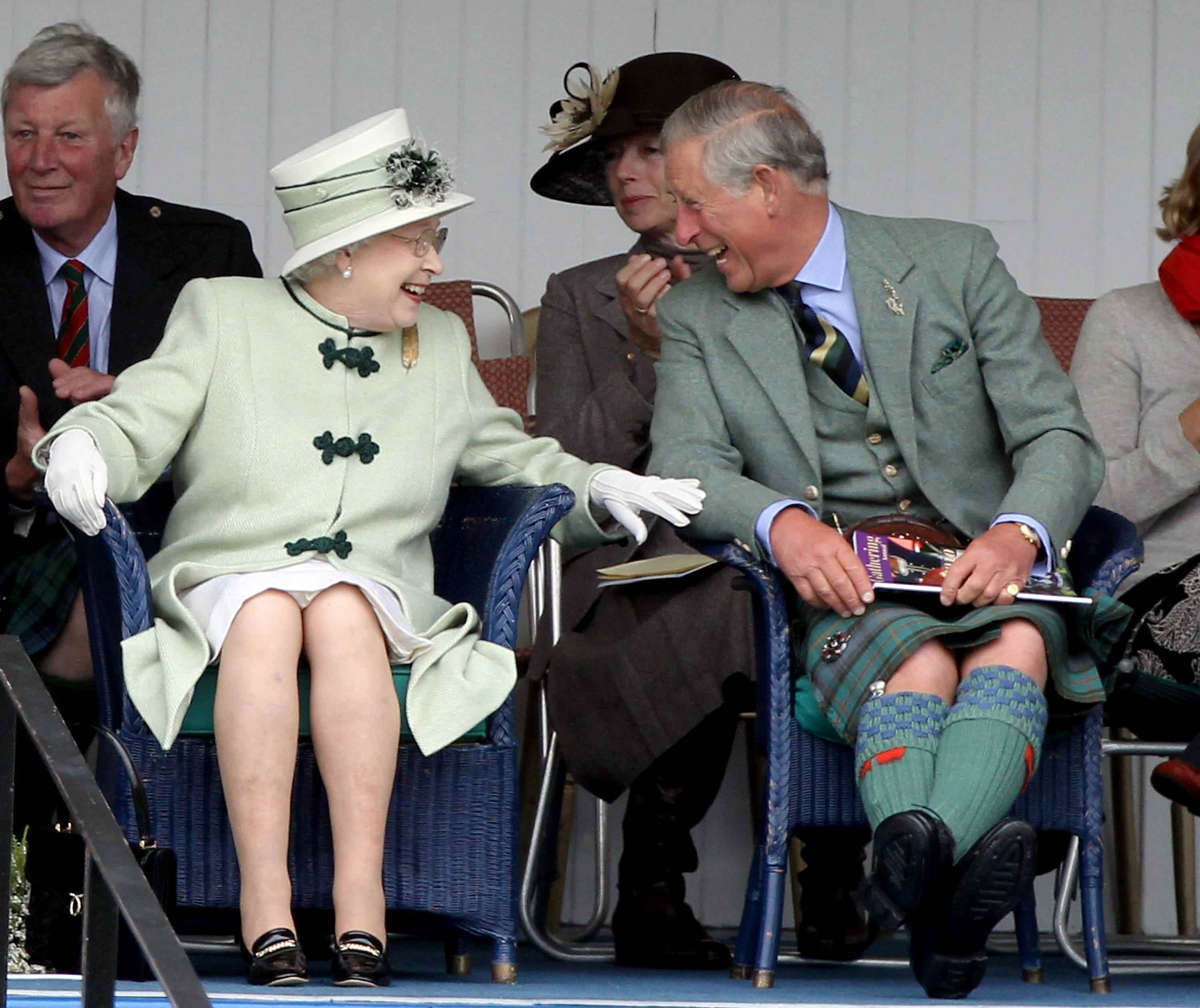 Queen Elizabeth und Prinz Charles lachen, als sie sich ein Tauziehen ansehen