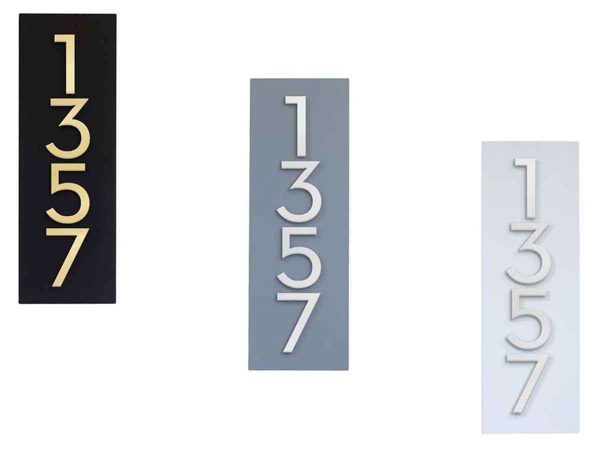 Drei rechteckige Plaketten sind vertikal positioniert, wobei die Serifenzahlen „1357“ vertikal auf jeder in den Farben schwarze Plakette und goldener Text, graue Plakette und silberner Text und weiße Plakette und silberner Text verlaufen.