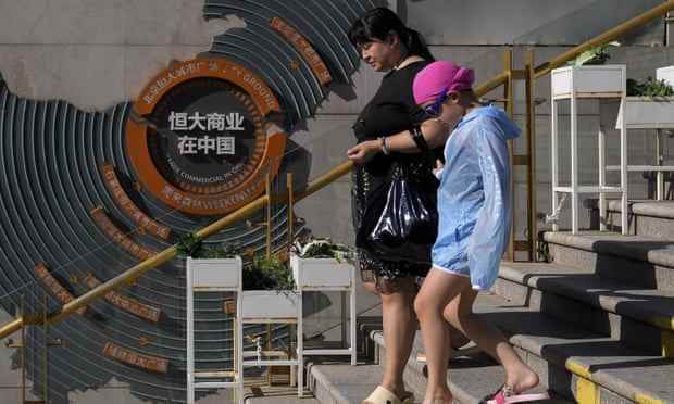 Menschen gehen in Peking an einer Karte vorbei, die Entwicklungsprojekte von Evergrande in China zeigt.