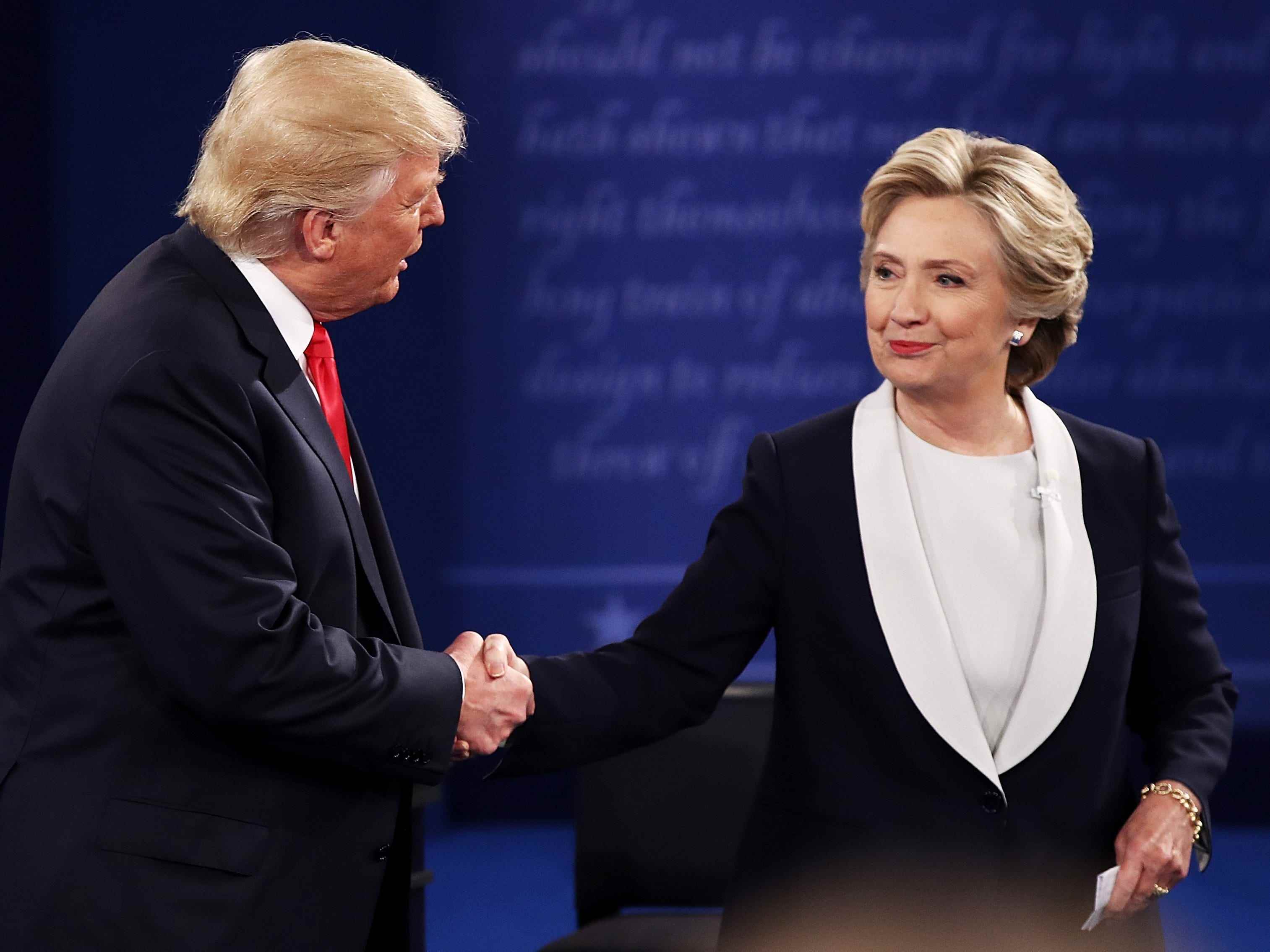 Der republikanische Präsidentschaftskandidat Donald Trump (L) schüttelt der demokratischen Präsidentschaftskandidaten, der ehemaligen Außenministerin Hillary Clinton, während der Rathausdebatte an der Washington University am 9. Oktober 2016 in St. Louis, Missouri, die Hand.
