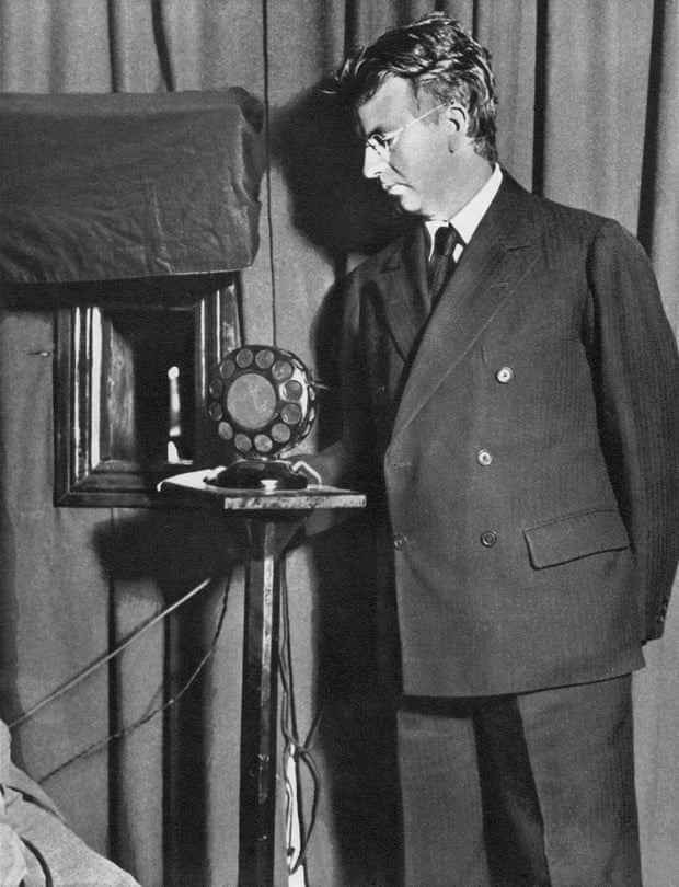 John Logie Baird, einer der Erfinder des mechanischen Fernsehens, sieht sich das erste Fernsehspiel „Der Mann mit einer Blume im Mund“ an.