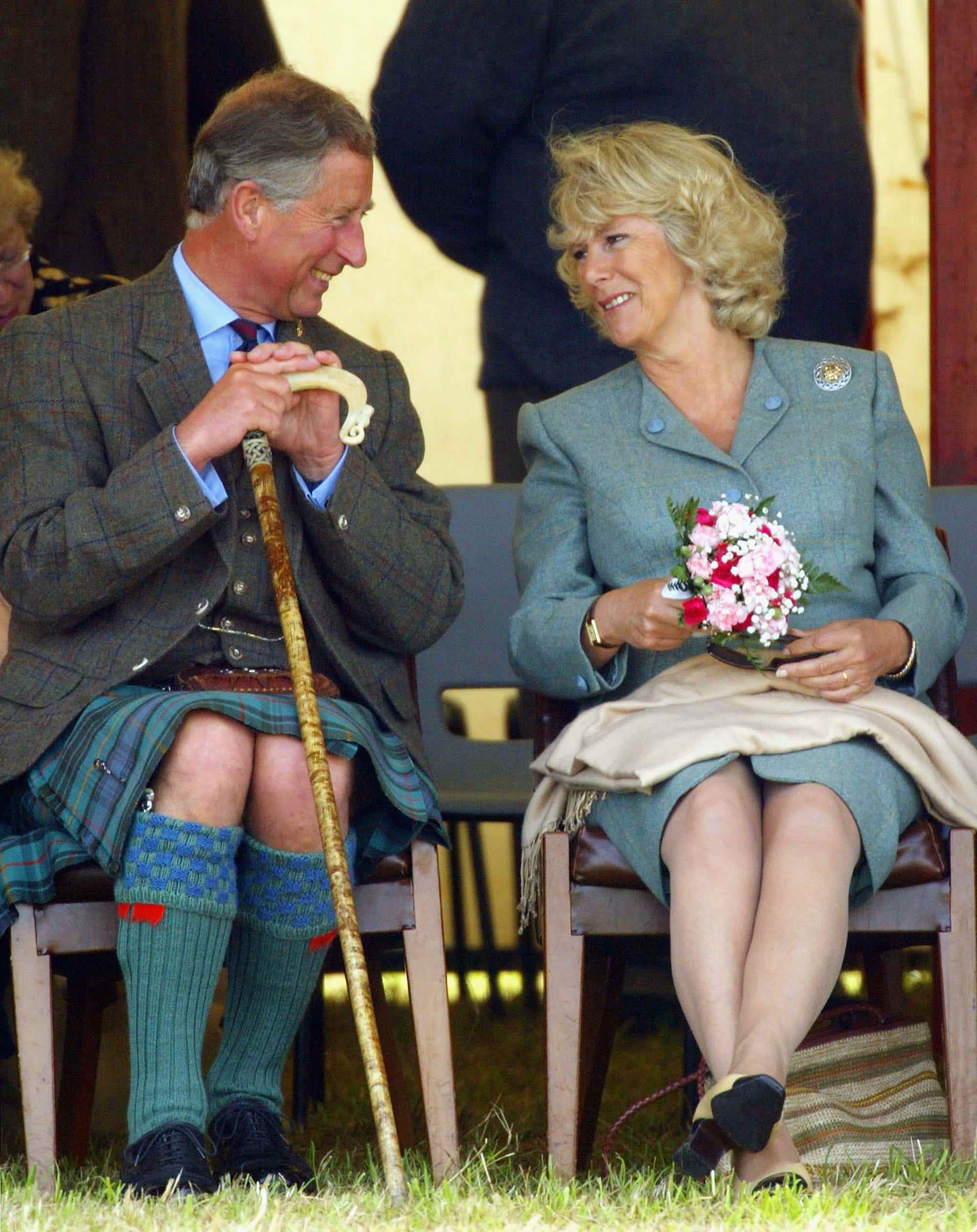 König Charles III und Camilla Parker sehen sich an.