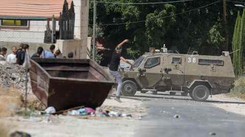 Ein Palästinenser schleudert bei Zusammenstößen in Dschenin am 28. September einen Stein auf ein Fahrzeug der israelischen Armee.