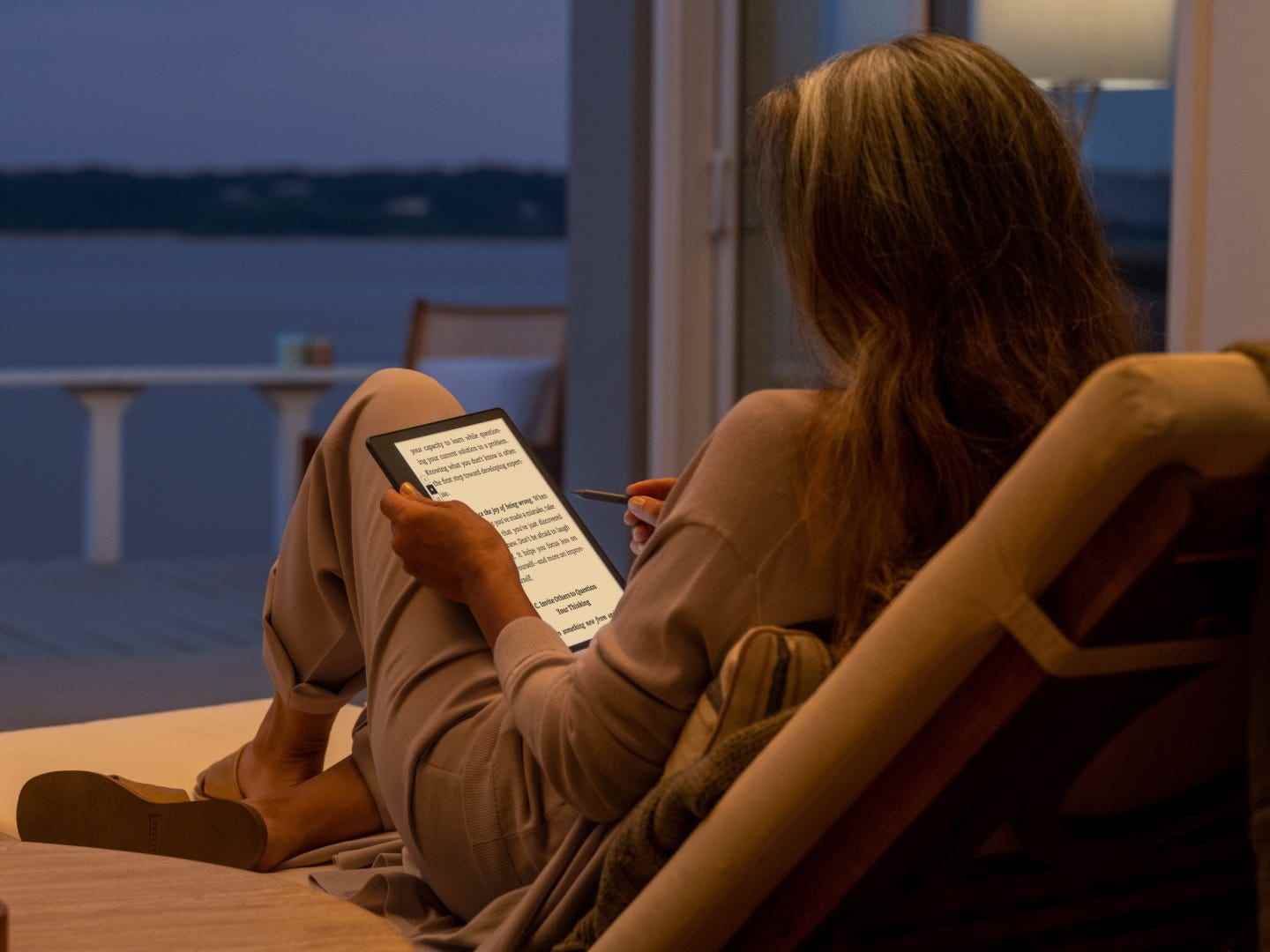 Eine Person benutzt nachts den Amazon Kindle Scribe.