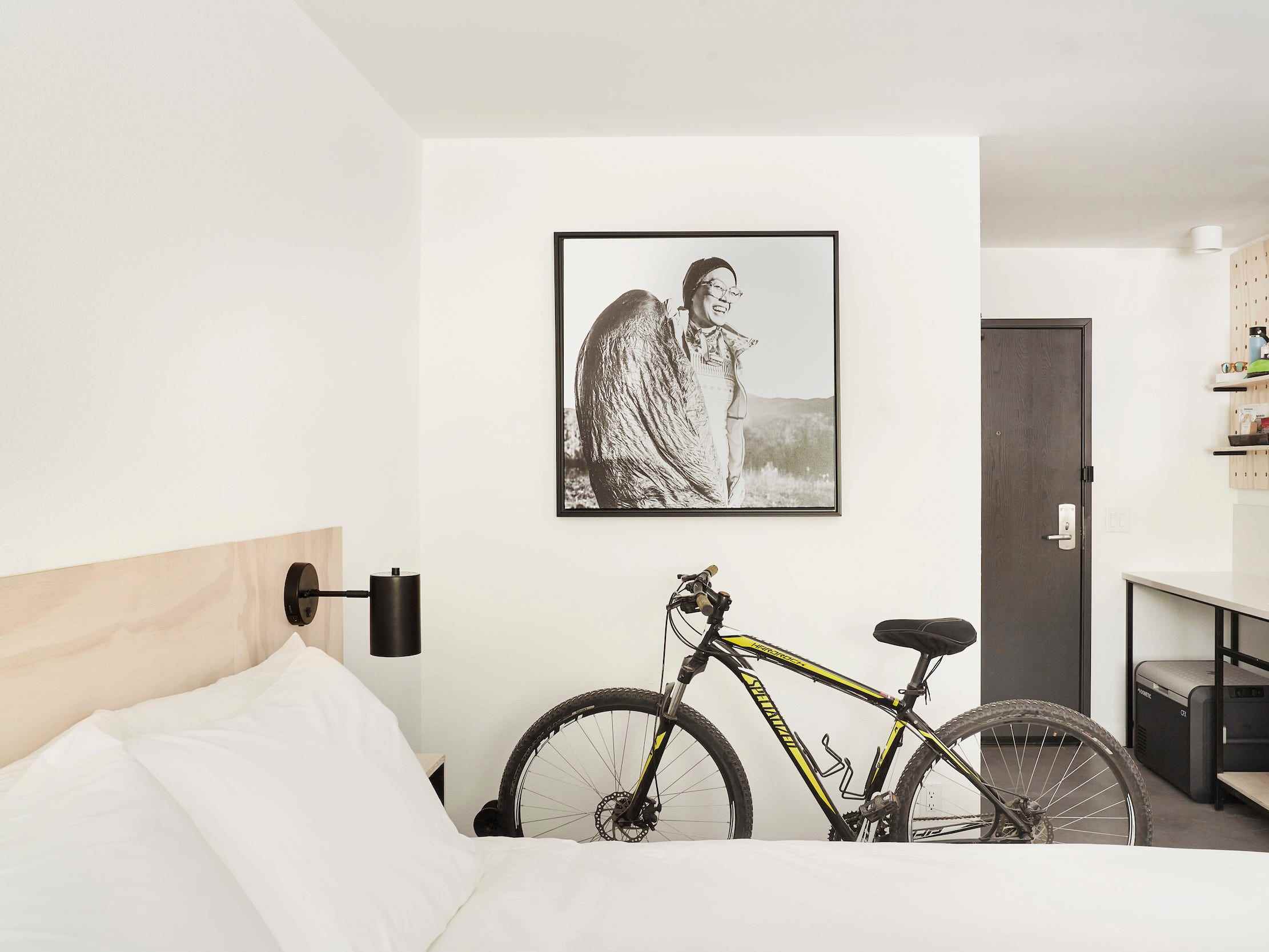 In einem Hotelzimmer der Field Station mit einem Bett, Möbeln und einem Fahrrad
