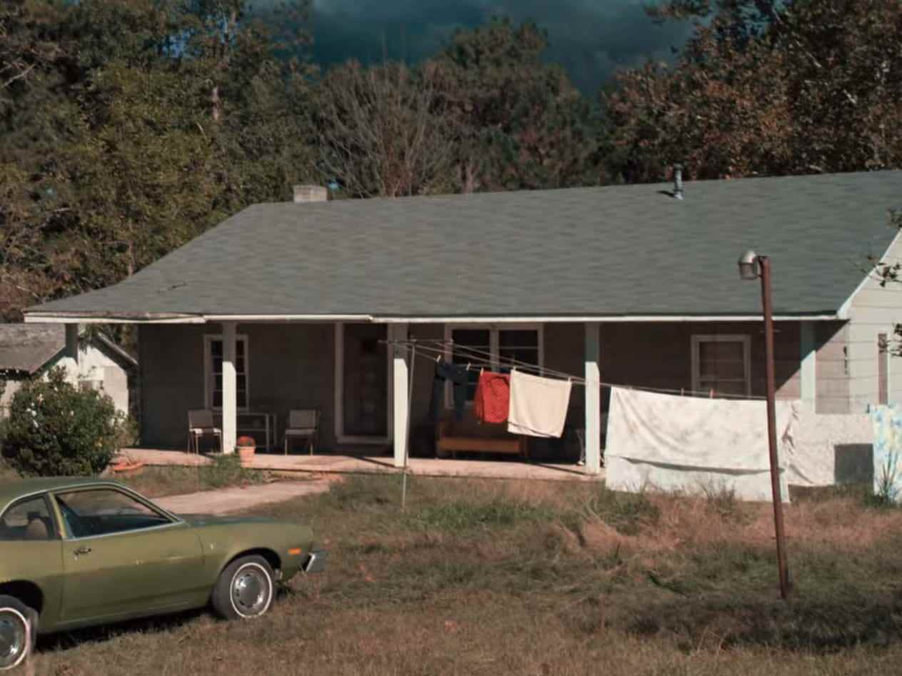 das Haus der Byers in fremden Dingen, mit Wäsche, die auf der Veranda hängt, und einem grünen Auto, das davor geparkt ist