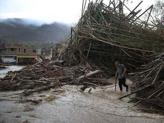 Ein Mann geht durch eine Straße, die durch starke Regenfälle nach dem Hurrikan Maria in Puerto Rico in einen Fluss verwandelt wurde