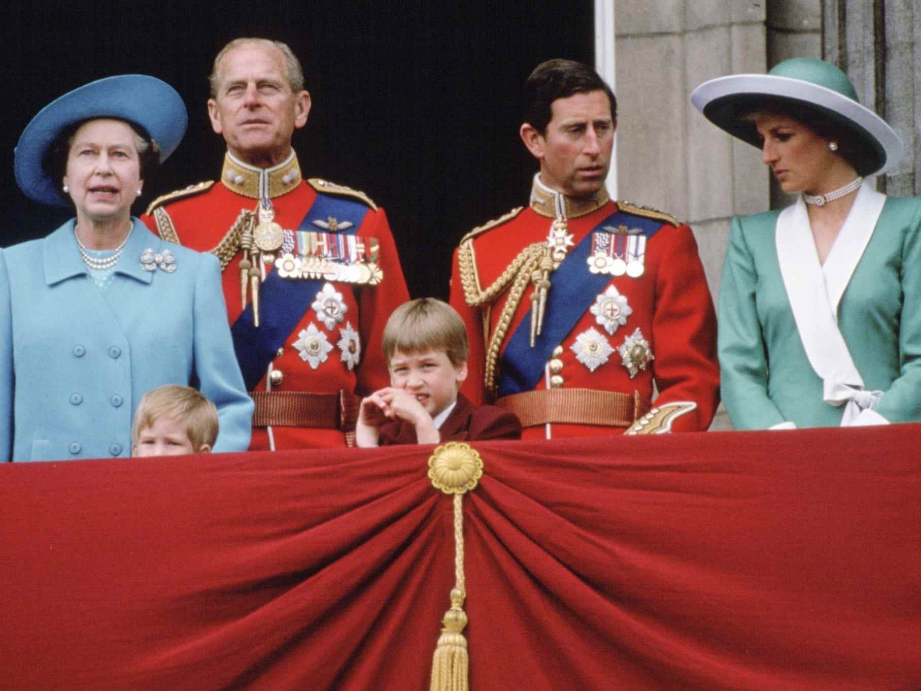Queen Elizabeth, Prinz Philip, Prinz Harry, Prinz William, Prinz Charles und Prinzessin Diana stehen auf einem Balkon.