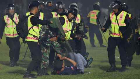 Sicherheitsbeamte nehmen einen Fan während eines Zusammenstoßes zwischen Anhängern zweier indonesischer Fußballmannschaften im Kanjuruhan-Stadion in Malang, Ost-Java, Indonesien, fest.