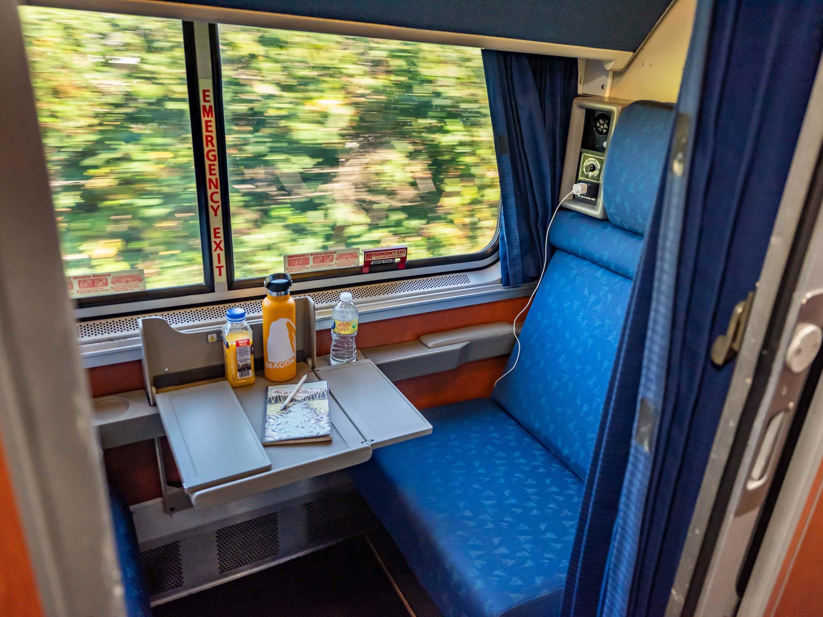 Waggon mit herausgezogenem Tablett und verschwommenen Bäumen im Fenster, während der Zug vorbeifährt