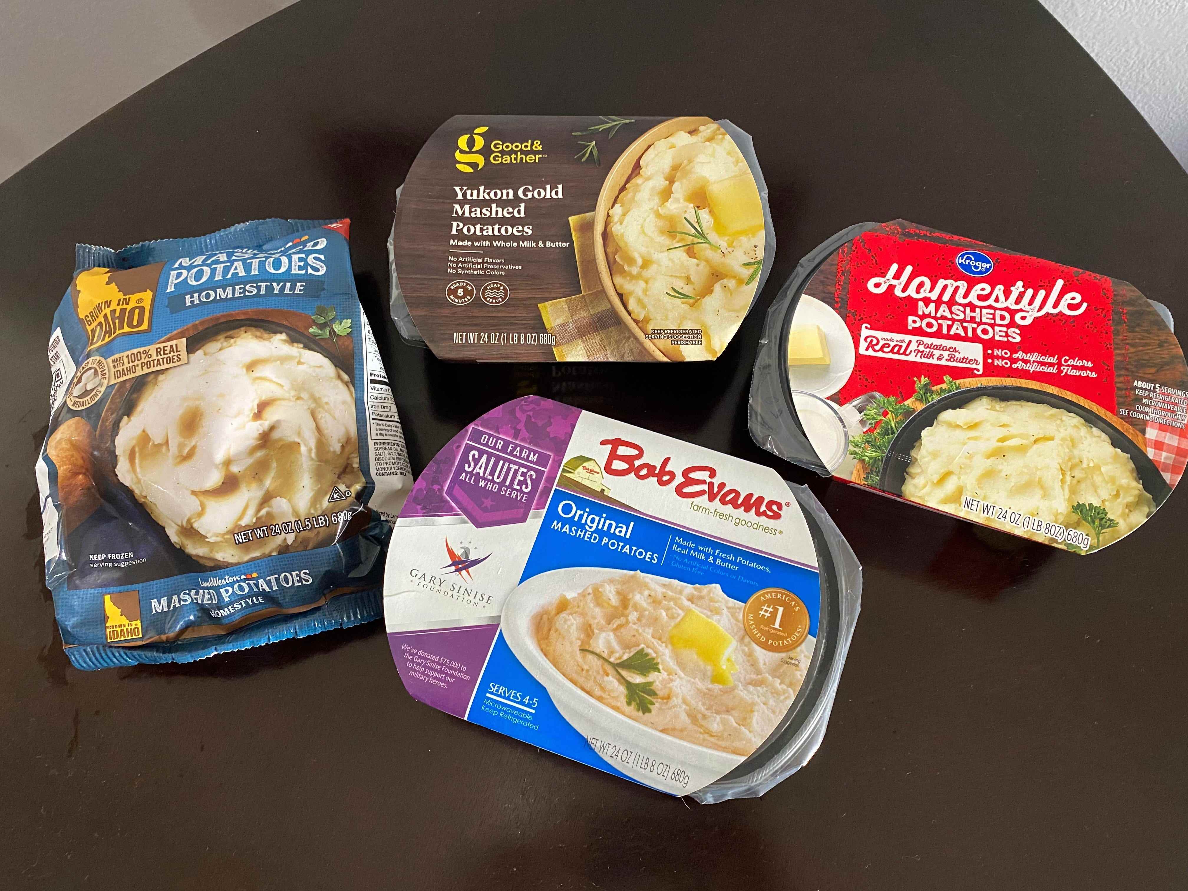 vier Packungen verschiedener Marken von vorgefertigtem Kartoffelpüree