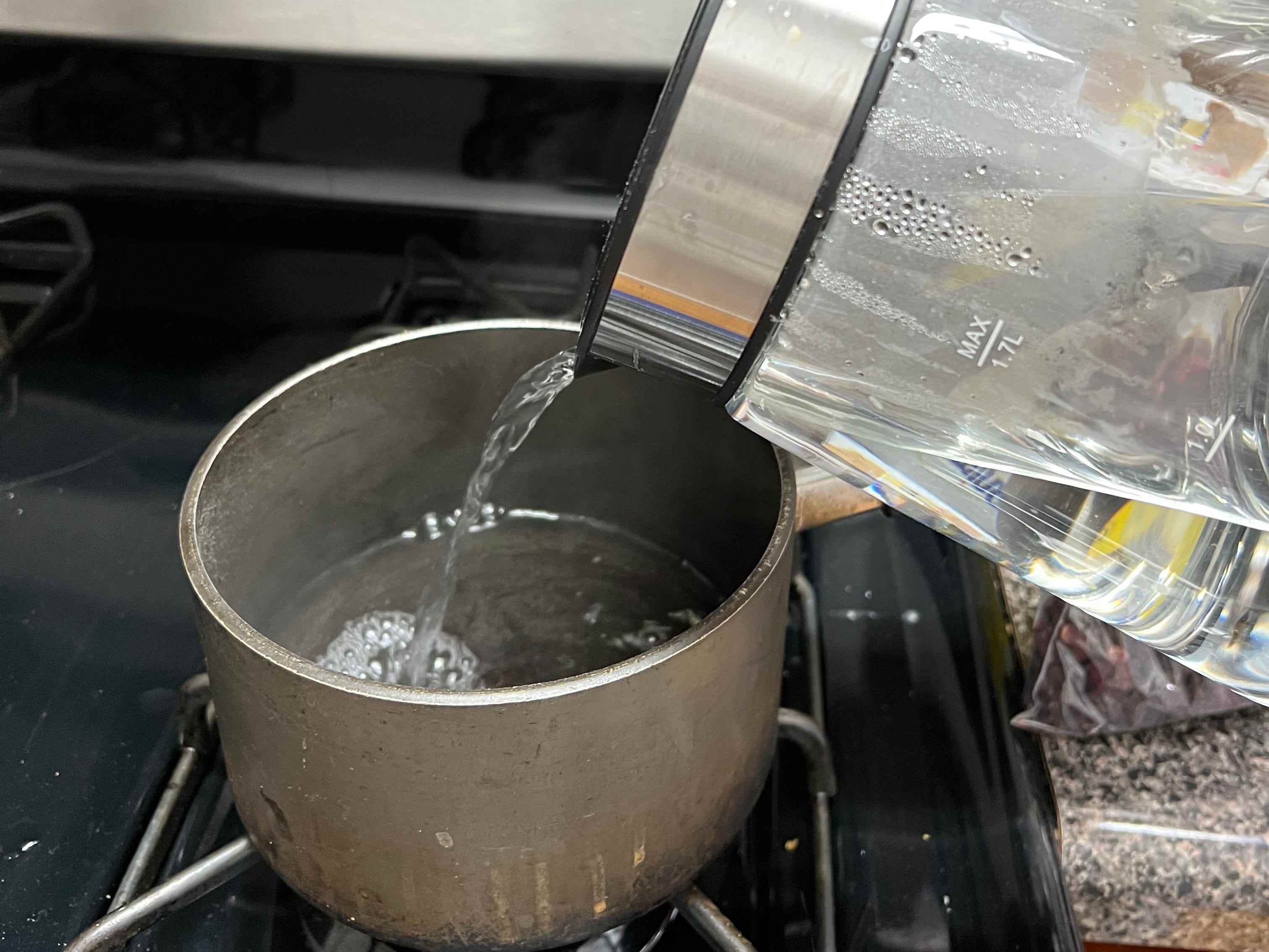 Gießen Sie heißes Wasser in einen Topf für ein Jamaika-Rezept.