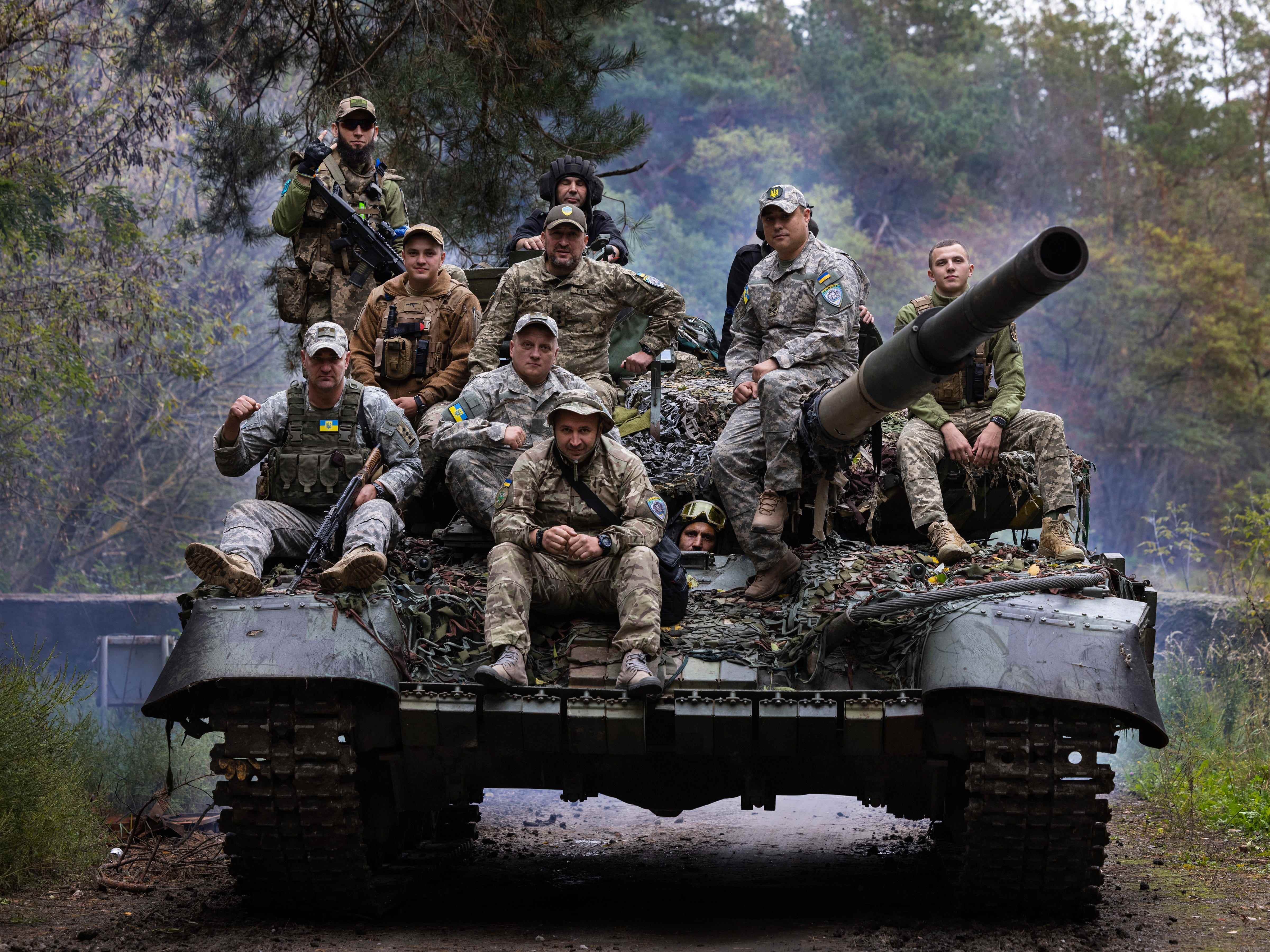 Ukrainische Truppen reiten am 26. September 2022 in Charkiw, Ukraine, in einem Waldgebiet außerhalb der Stadt auf einen reparierten russischen Panzer.