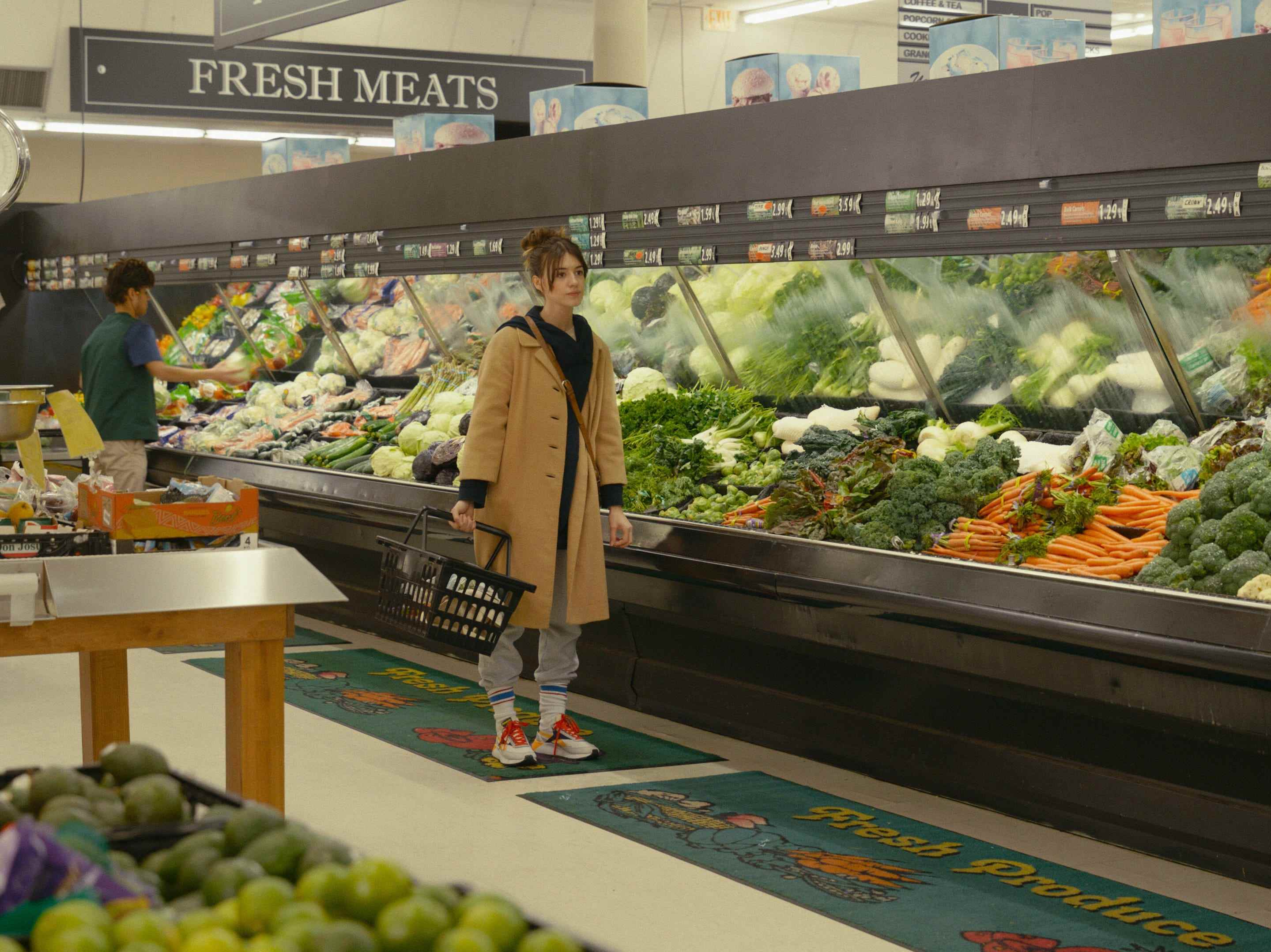 Ein Standbild aus dem Horrorfilm „Fresh“, in dem eine Frau im Gemüsegang eines Lebensmittelladens steht.