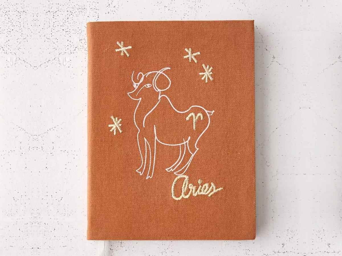 Ein mit Tierkreiszeichen besticktes Tagebuch mit einem Widder und dem Text „Widder“.