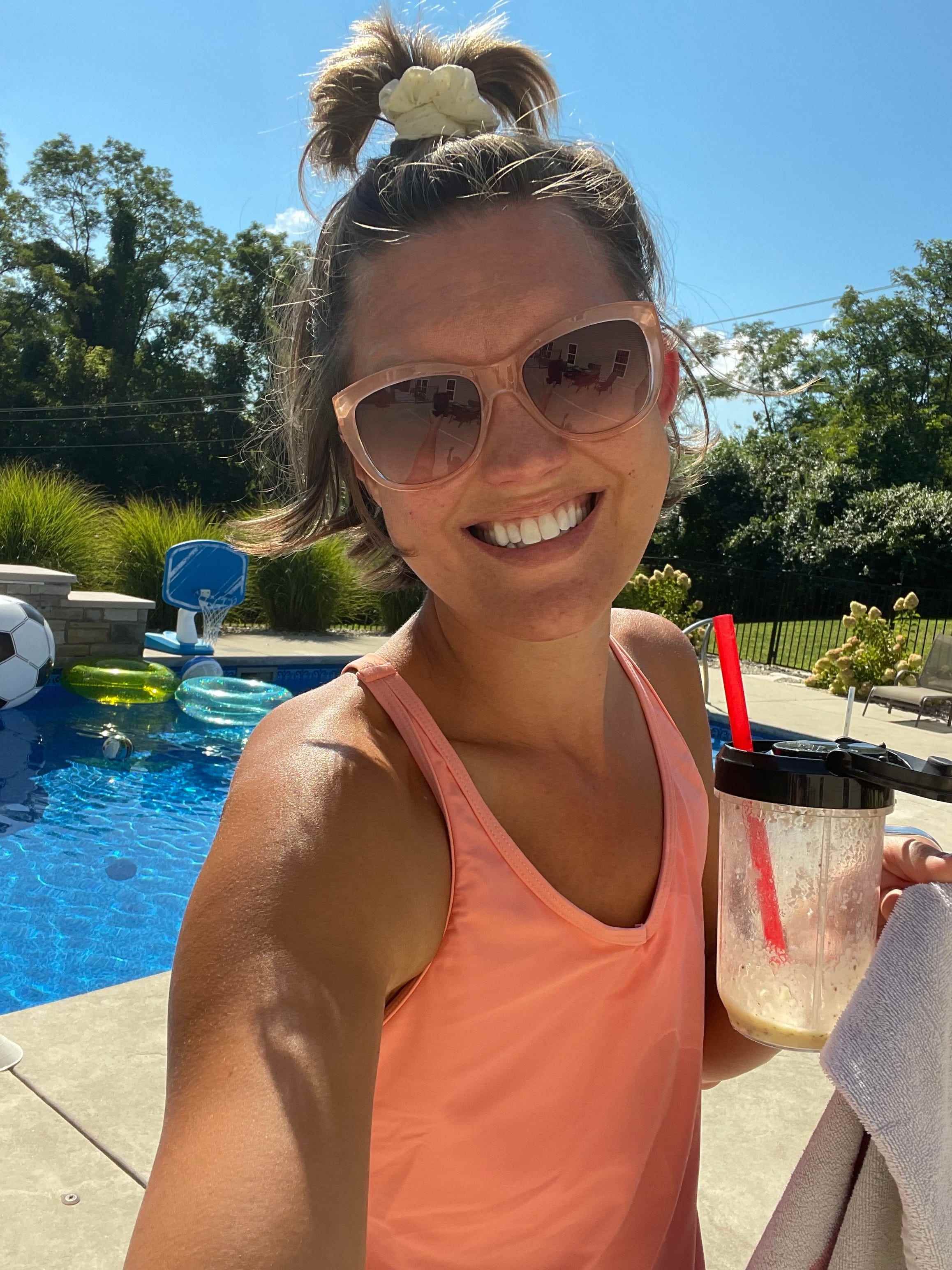 Rachel Garlinghouse trägt ein Tanktop und eine Sonnenbrille an einem Pool
