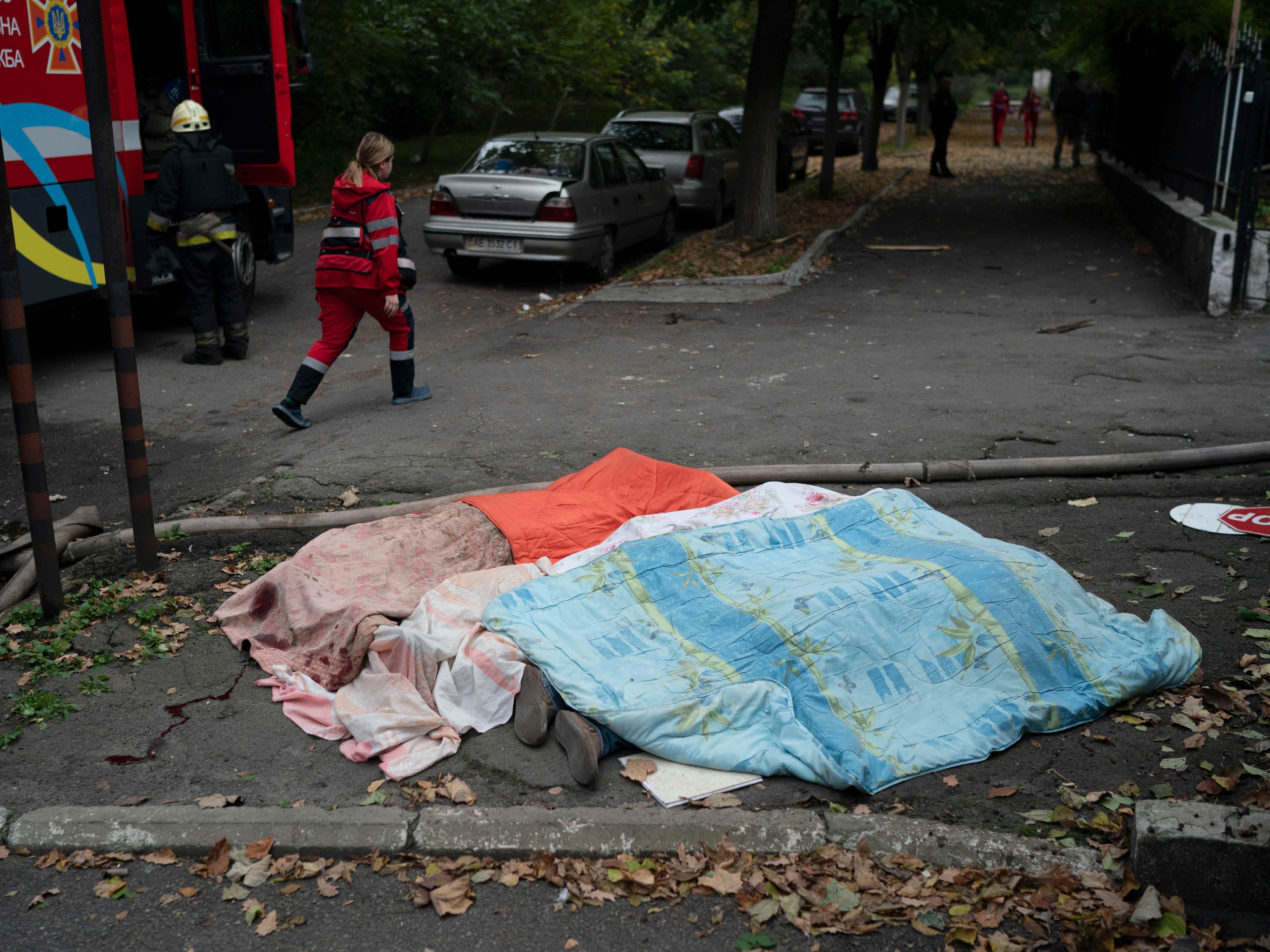 Drei mit Decken bedeckte Leichen in Dnipro, Ukraine.