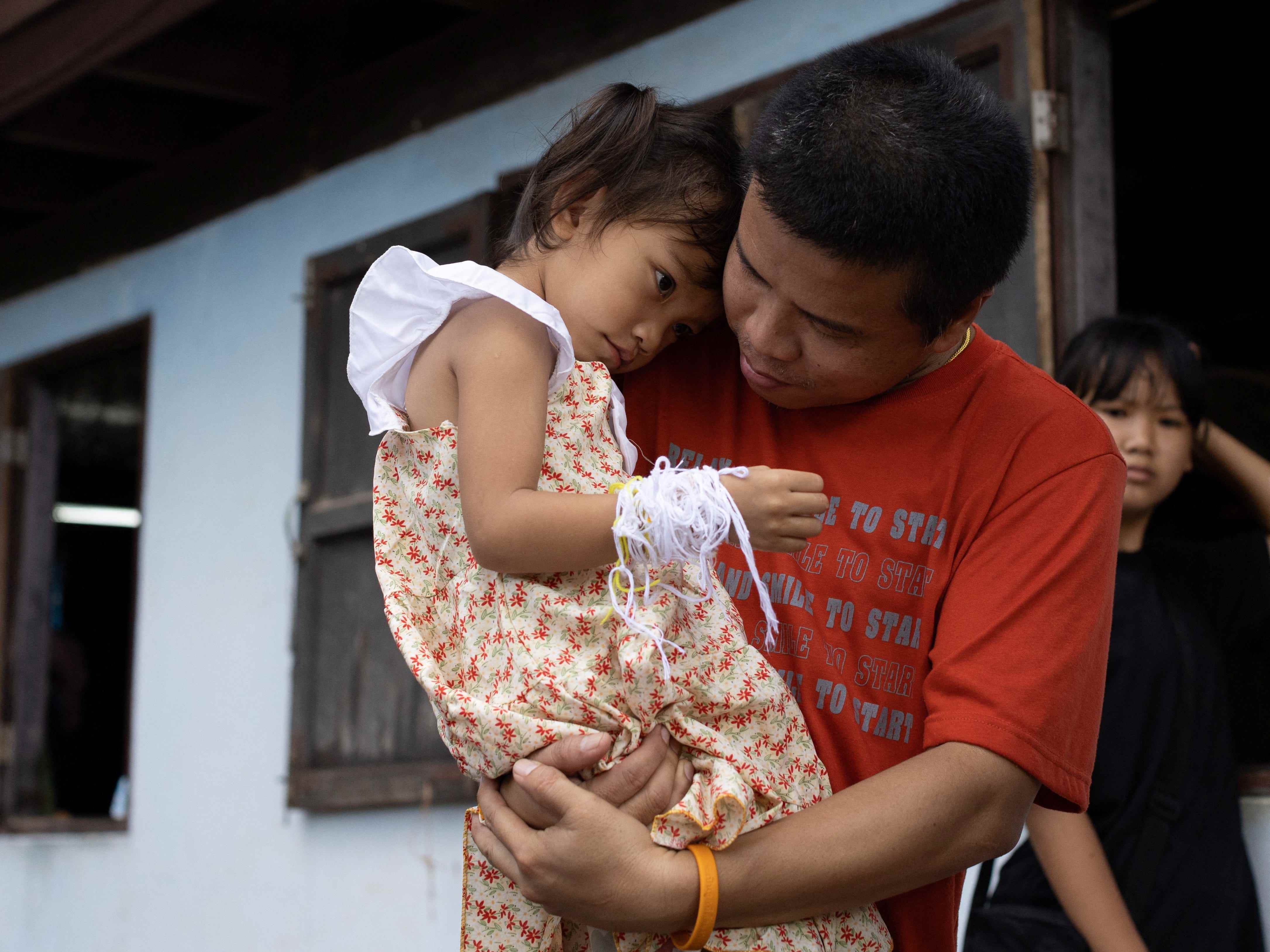Ein Bild von Tawatchai Supolwong, der seine Tochter Paveenut hält – die einzige Überlebende des thailändischen Massakers an Kindertagesstätten im Oktober 2022