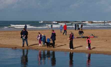 Familie, die während der Herbsthalbzeit, Bude, am Strand spielt