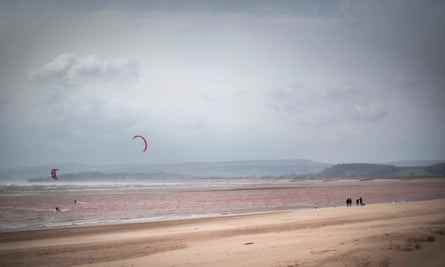 Wanderer und Kitesurfer am Strand von Exmouth