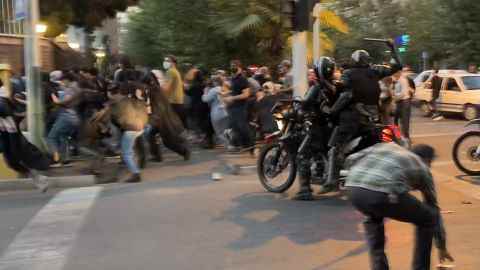 Ein iranischer Polizist auf einem Motorrad hebt letzten Monat einen Schlagstock, um Demonstranten zu zerstreuen.
