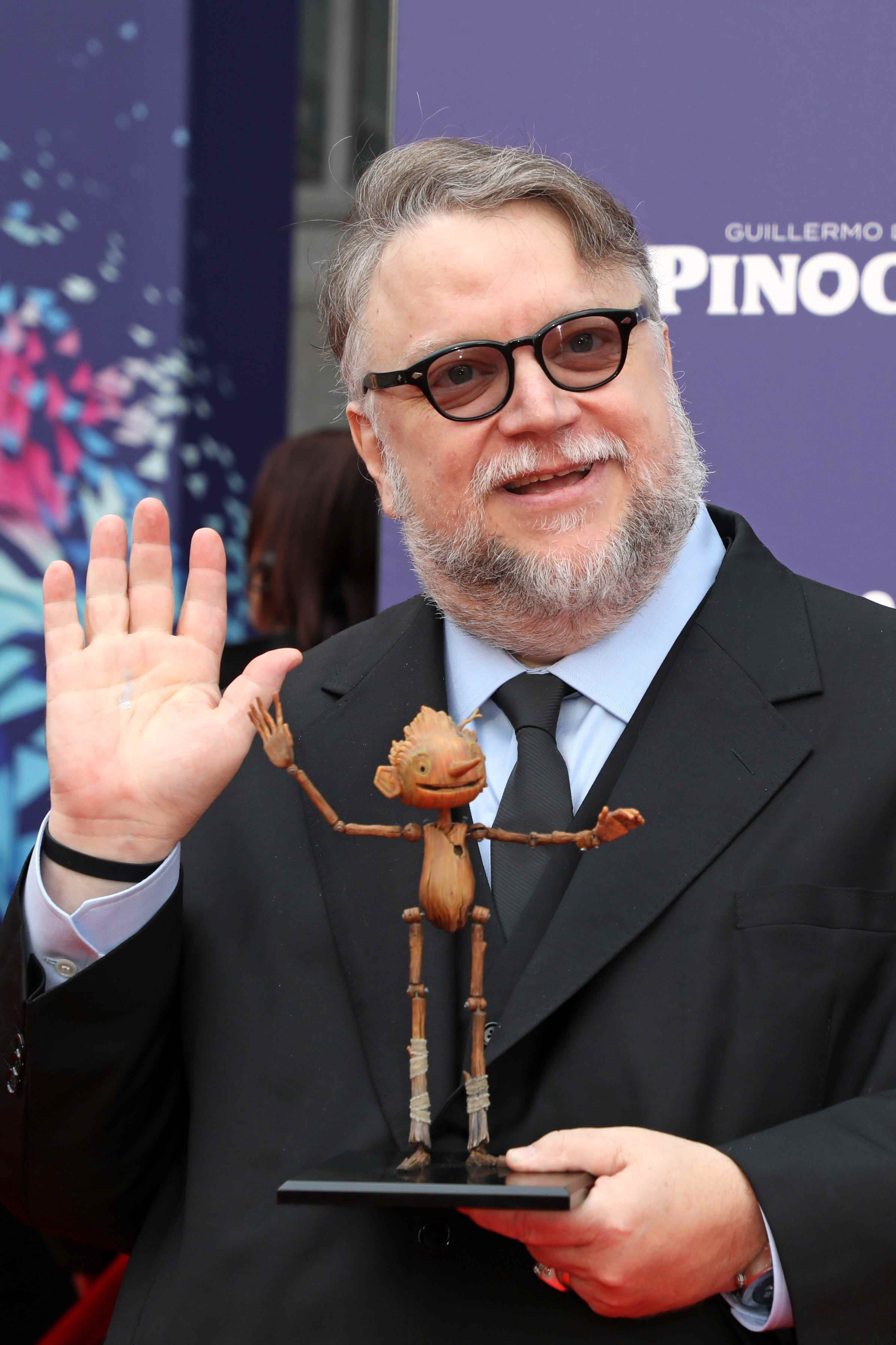 Regisseur Guillermo del Toro posiert mit einer kleinen Nachbildung von Pinocchio während der Weltpremiere von „Guillermo Del Toros Pinocchio“ während des London Film Festivals am 15. Oktober 2022 in London, England.