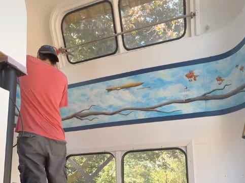 Scott konserviert das Gemälde im Bus, das aus seiner Grilled Cheese Grill-Zeit stammt.