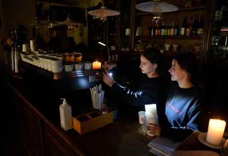 Mitarbeiter bereiten Kaffee in einem unbeleuchteten Café in Lyiv zu.