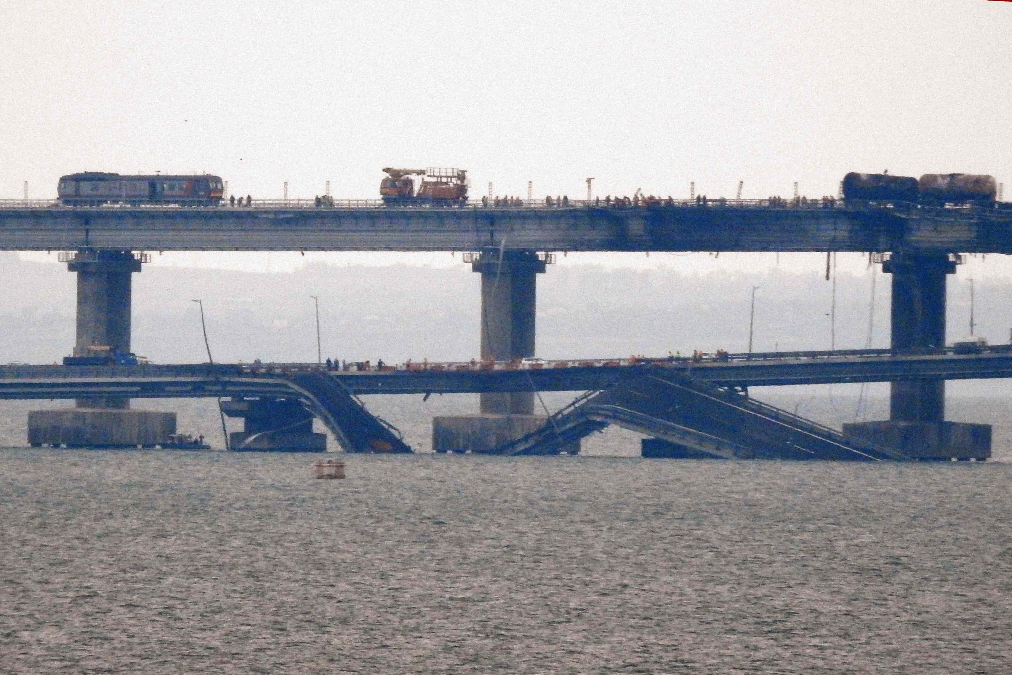 Arbeiter restaurieren am 9. Oktober 2022, einen Tag nachdem sie durch eine Explosion beschädigt wurde, die Eisenbahngleise auf der Kertsch-Brücke, die die Krim mit Russland verbindet, in der Nähe von Kertsch.