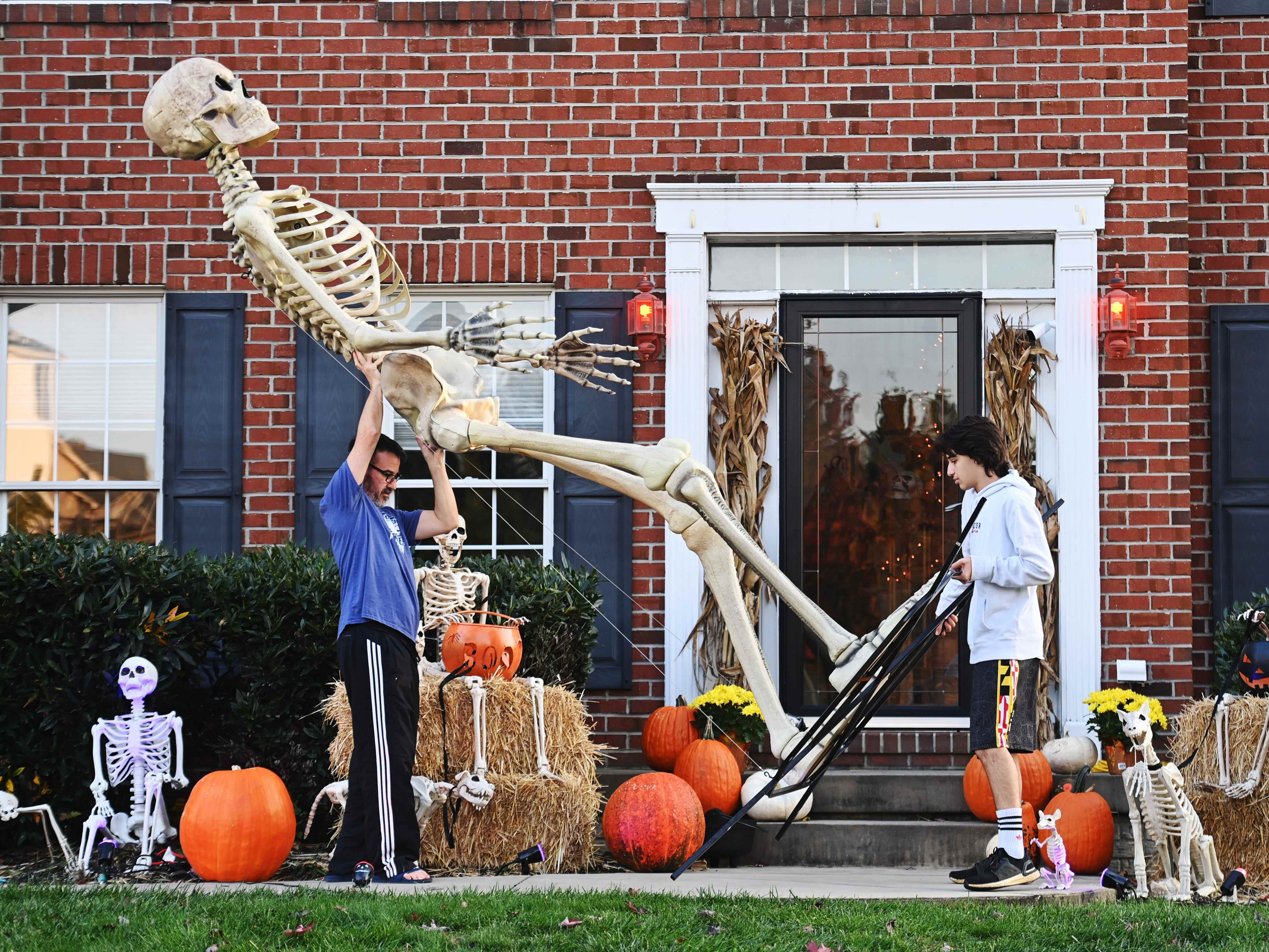 Ein Vater und sein Sohn lagern nach Halloween ihr 12 Fuß großes Home Depot-Skelett ein.