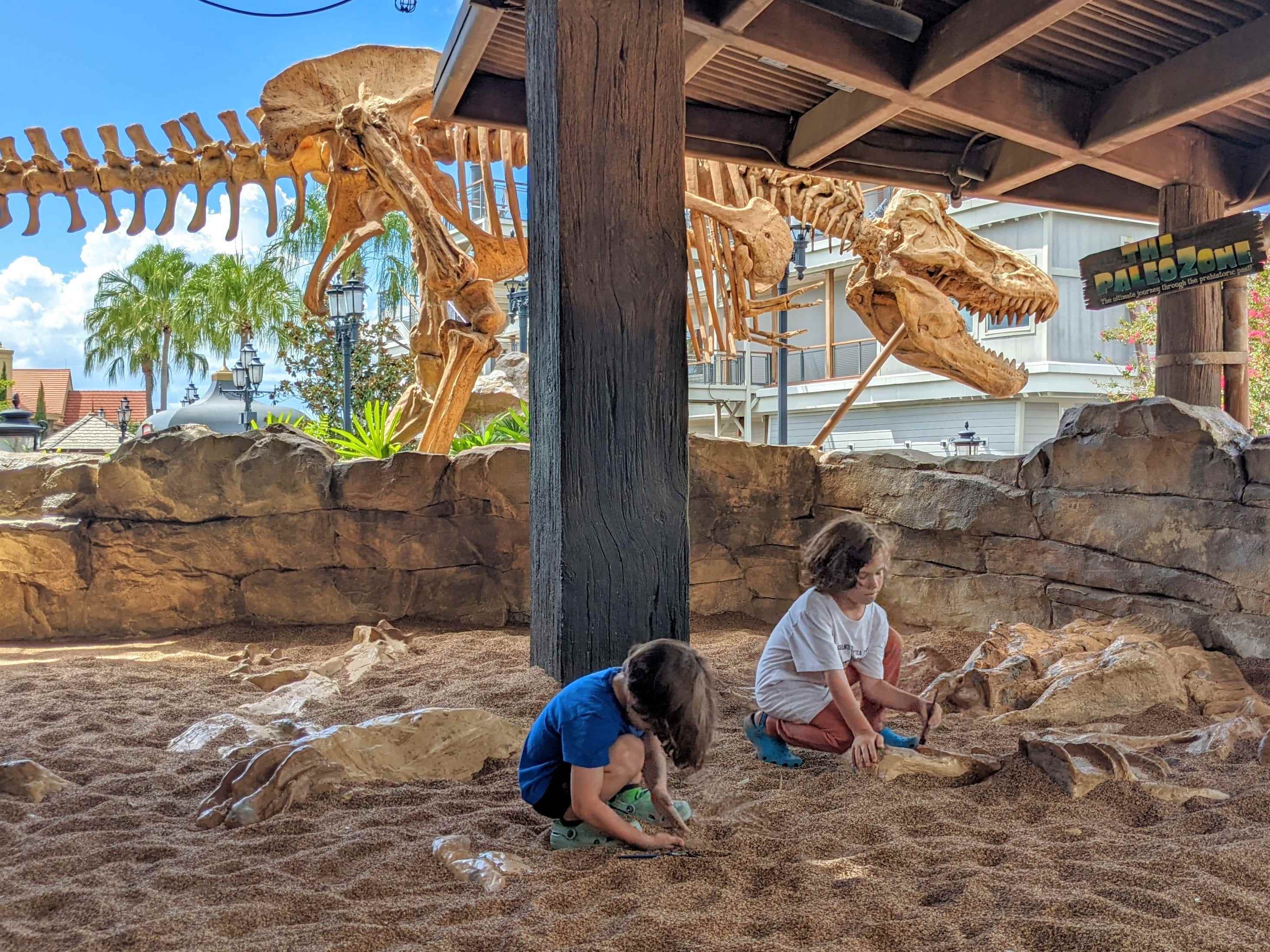Kinder spielen im Grabenbereich des T-Rex-Cafés in Disney Springs 