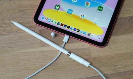 Der Apple Pencil der ersten Generation, der über ein USB-C-Kabel und einen Lightning-Adapter mit dem neuen iPad verbunden ist.