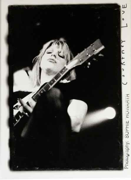 Schwarz-Weiß-Bild von Courtney Love, die Gitarre spielt, aufgenommen von unten