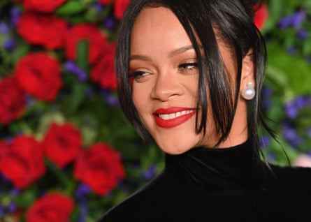 Rihanna lächelt in Nahaufnahme vor Blumenhintergrund