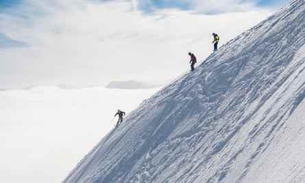 Skifahrer am steilen schneebedeckten Hang
