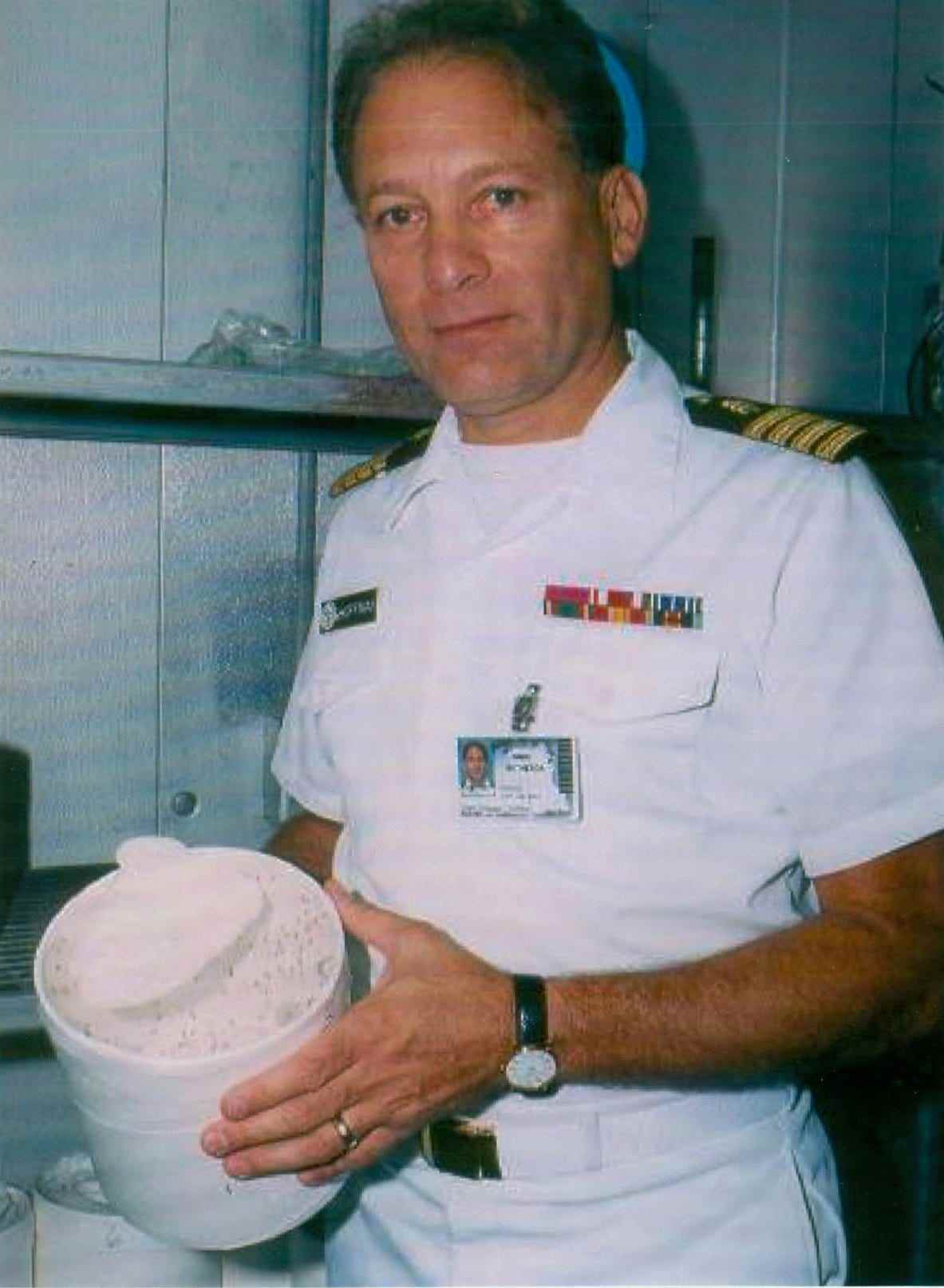 Mann in Marineuniform, der Malariamücken in einem Behälter hält