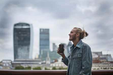 Nachdenklicher Hipster trinkt Kaffee auf der Straße in London.