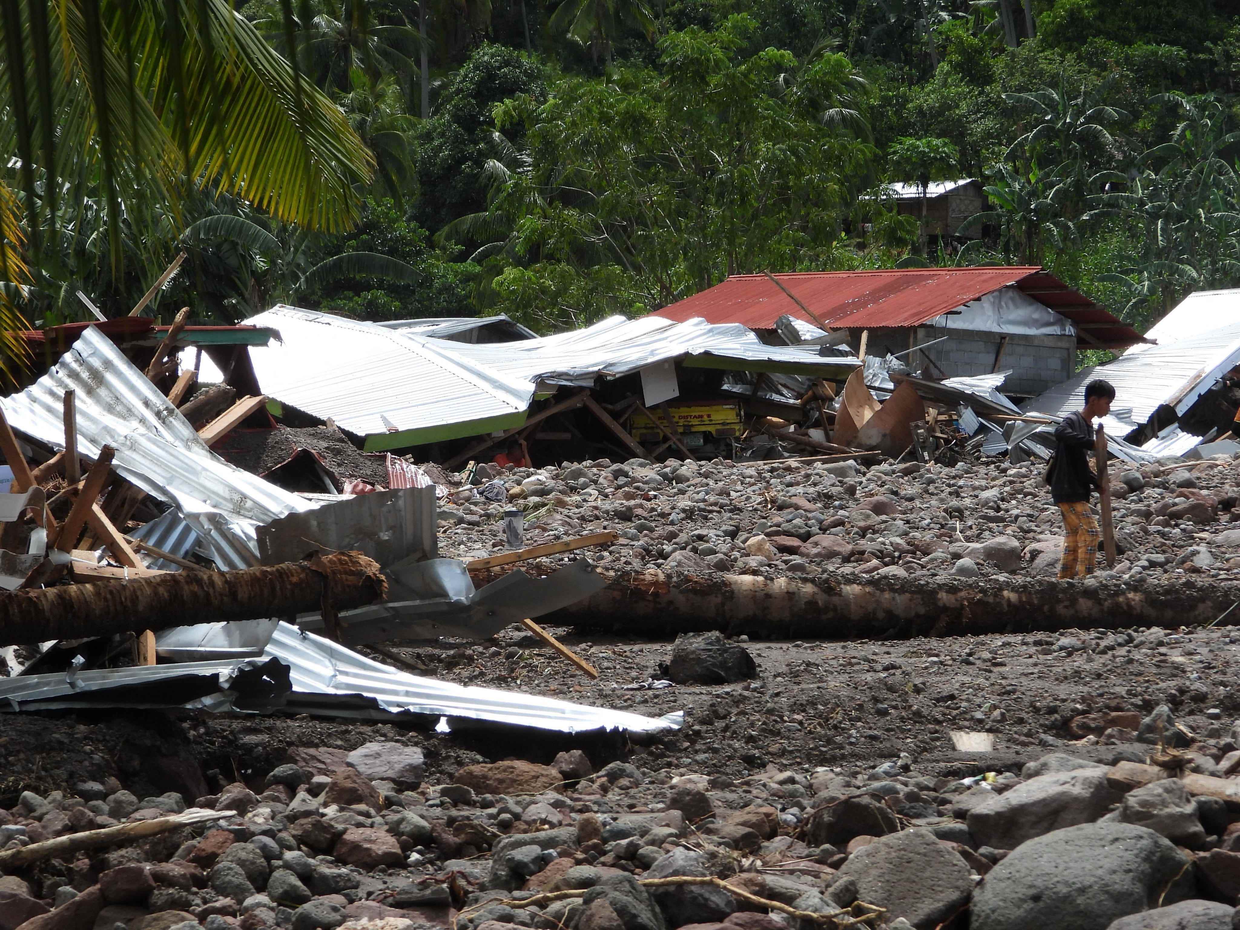 Ein Bewohner geht am 29. Oktober 2022 an einem zerstörten Haus im von einem Erdrutsch betroffenen Dorf Kusiong in Datu Odin Sinsuat in der südphilippinischen Provinz Maguindanao vorbei.