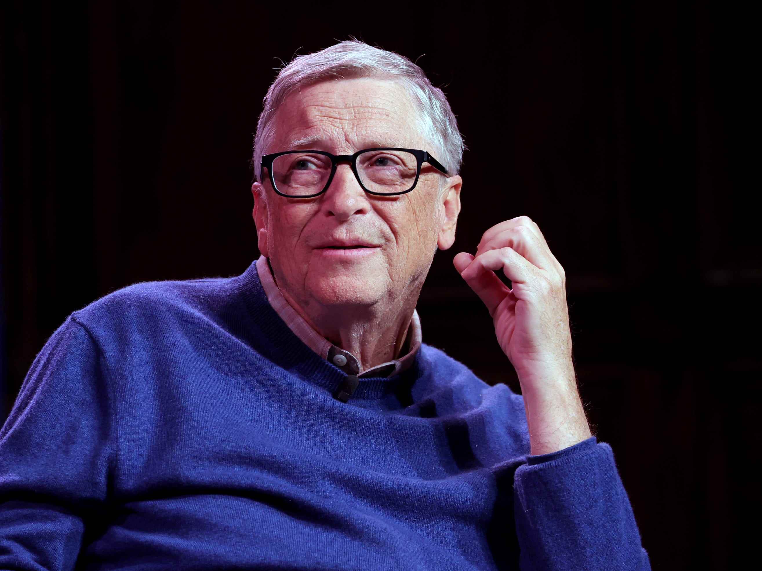 Bill Gates auf der Bühne vor schwarzem Hintergrund.