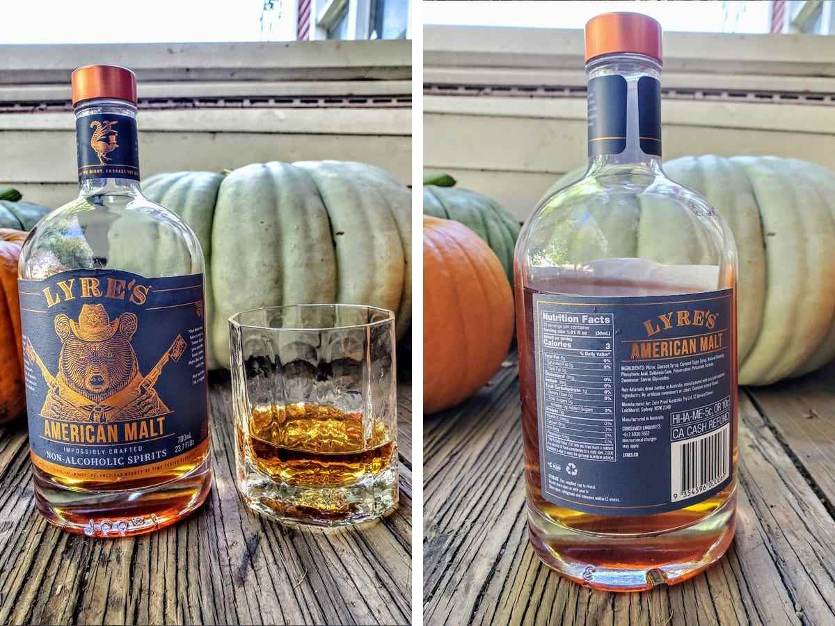 Eine Flasche Lyre's American Malt wird neben einem Glas des alkoholfreien Whiskys auf einer Veranda in der Nähe von Kürbissen ausgestellt, und die Nährwertangaben sind auf der Rückseite der Flasche angegeben.